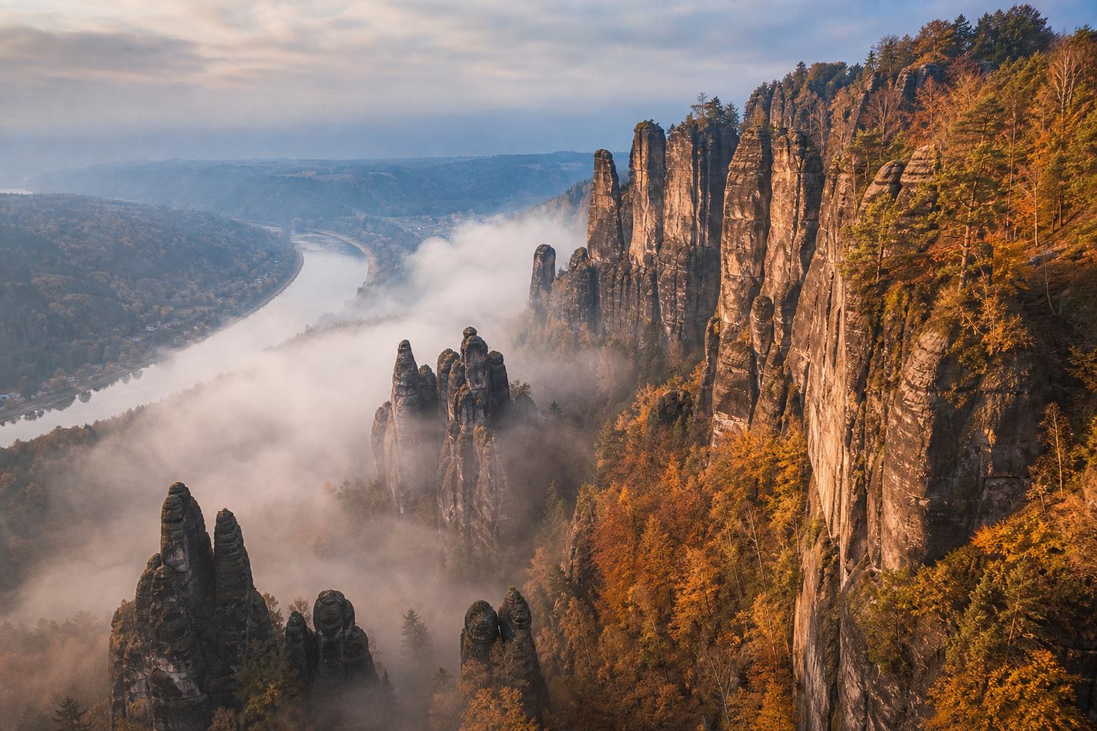 Herbstnebel und kupferner Wald zwischen Sandsteintürmen
